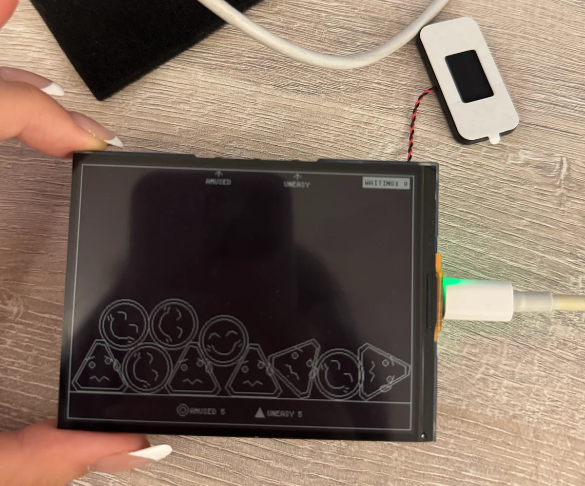The RLCD device, with accumulated emotion expressions and physical buttons.