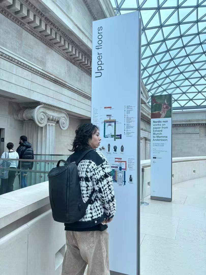 Visitor checking a tall directional sign in the British Museum Great Court