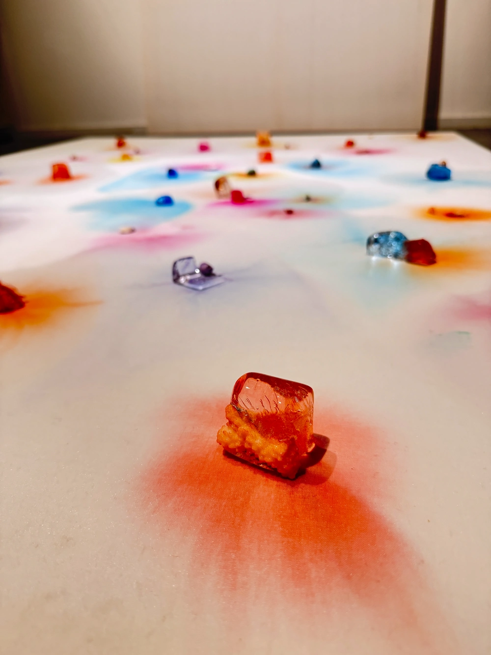An orange melting ice block and its surrounding pigment