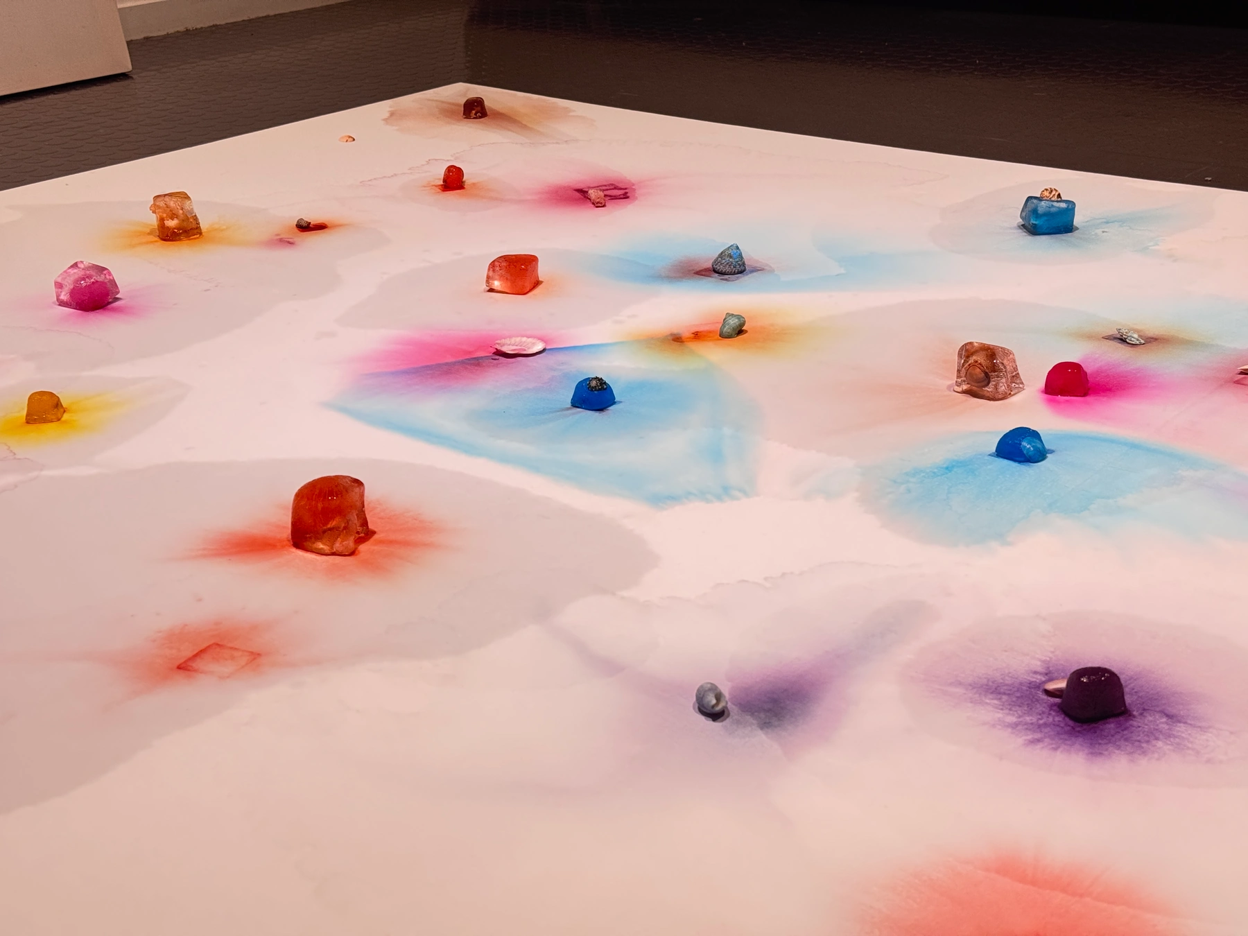 Coloured ice and spreading pigment on the horizontal white canvas